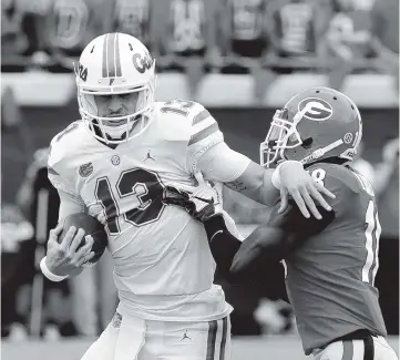  ?? JOHN RAOUX AP ?? UF quarterbac­k Feleipe Franks has nowhere to go as he’s wrapped up by Georgia defensive back Deandre Baker in the first half on Saturday.