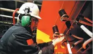  ?? YU FANGPING / FOR CHINA DAILY ?? A worker installs cables at an oil drilling platform near Qingdao, Shandong province.