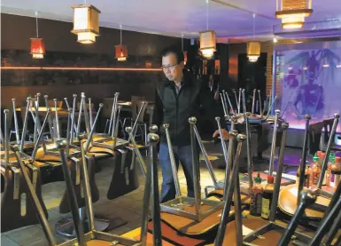  ?? Paul Chinn / The Chronicle ?? Green Papaya owner Thai Van walks through his temporaril­y closed restaurant in San Francisco.