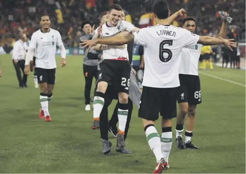  ??  ?? 0 Andrew Robertson, centre, celebrates with his Liverpool team-mates after seeing off Roma to set up a final against Real Madrid.