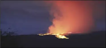  ?? ASSOCIATED PRESS ?? Lava pours out of the summit crater of Mauna Loa at about 6:35 a.m., Monday, as seen from Gilbert Kahele Recreation Area on Maunakea, Hawaii. Mauna Loa, the world’s largest active volcano, began spewing ash and debris from its summit, prompting civil defense officials to warn residents on Monday to prepare in case the eruption causes lava to flow toward communitie­s.