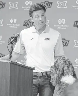  ?? [AP PHOTO] ?? OSU football coach Mike Gundy and Kenzie hold a recent press conference.