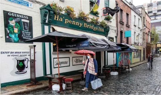  ?? Bild: Paul FAITH/AP/TT ?? En kvinna passerar en nedstängd pub i Irlands huvudstad Dublin på måndagen.