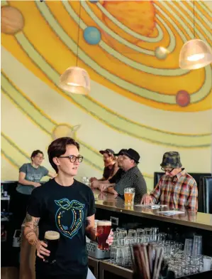  ??  ?? Above, from left: A mural of the solar system serves as an out-of-this-world backdrop at space-themed Ecliptic Brewing; a dried hop flower at Hopworks Urban Brewery. Opposite,from top: Brewmaster Jeff Edgerton at BridgePort; the same brewery’s former factory building in downtown Portland.