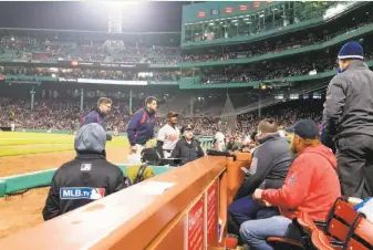  ?? Avi Miller via Associated Press ?? In a photo provided by Avi Miller, a security officer looks into the stands after Baltimore center fielder Adam Jones was taunted by racial slurs at Fenway Park on Monday.