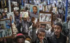  ??  ?? Members of Ethiopia’s Jewish community hold pictures of their relatives in Israel, during a solidarity event at the synagogue in Addis Ababa, Ethiopia on Wednesday. AP PHOTO/MULUGETA AYENE