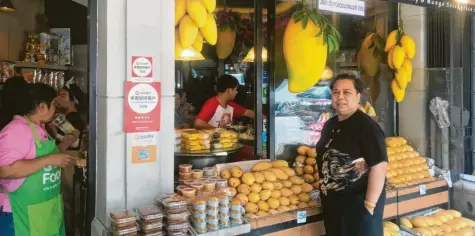  ?? Foto: Christoph Sator, dpa ?? Bei „Mae Varee“in Bangkok gibt es Mangos in allen möglichen Variatione­n. Rechts siehst du die Besitzerin des Ladens.