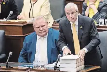  ?? NATHAN DENETTE THE CANADIAN PRESS ?? Ontario Premier Doug Ford watches as Finance Minister Vic Fedeli tables the government's economic update at Queen's Park on Thursday.