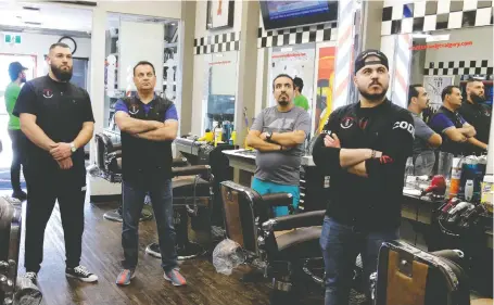  ?? DARREN MAKOWICHUK ?? Rico (Jalal El-saghir), second from left, owner of the Razors Edge Barber Shoppe, watches with staff on Wednesday as the province announces barber shops will not be able to reopen for another 10 days in Calgary.