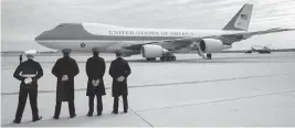  ?? ANDREW HARNIK AP ?? Military personnel watch as Air Force One, with President Donald Trump aboard, prepares to depart Andrews Air Force Base in 2017. The plane is a highly customized 747.