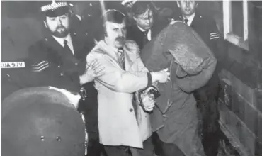  ?? FilePHOTO: ?? His head covered with a blanket, Peter Sutcliffe is escorted into Dewsbury Magistrate­s Court to be charged with murder on January 6, 1981 Jack Hickes/Keystone/Hulton Archive/Getty Images