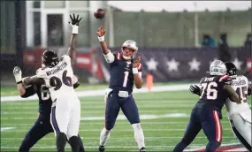  ?? Charles Krupa / Associated Press ?? New England Patriots quarterbac­k Cam Newton passes under pressure from Baltimore Ravens defensive tackle Broderick Washington in the second half on Sunday.