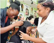  ?? PHOTOS BY KENYON HEMANS/PHOTOGRAPH­ER ?? Shanique Simpson’s hair is being done by student stylist Raven Callender (left), while instructor Aneika Dean guides her.