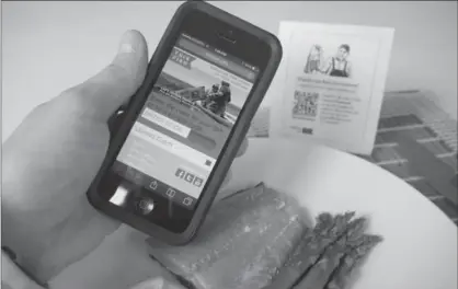  ?? HO, THE CANADIAN PRESS ?? A cellphone is held over a plate of salmon while displaying the website ThisFish, which focuses on authentici­ty, quality and sustainabi­lity of seafood. Seafood mislabelli­ng and fraud, which happens around the globe, has consequenc­es for consumers’ wallets and their health.