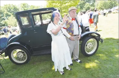  ?? Alex von Kleydorff / Hearst Connecticu­t Media ?? Don and Peggy Morey, dressed in period clothes, wave to friends in front of their 1926 Ford Model T coupe at the New England Auto Museum Father’s Day Car Show at Mathews Park in Norwalk on Sunday.