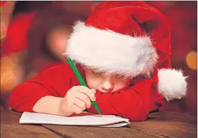  ??  ?? Dear Santa: A young letter writer with important mail for Saint Nick