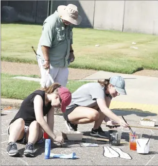  ?? Brodie Johnson • Times-Herald ?? A new crosswalk was being painted today at the Rosser and Dillard streets intersecti­on. St. Francis County Farm Bureau staff, along with volunteers, began painting the crosswalk this morning. Volunteers Amber and Jodie Kelso work on one area of the project while Farm Bureau Agent Frank Adams paints another section in the background.