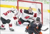  ??  ?? THE DUCKS’ Brandon Montour, foreground, scores against New Jersey goaltender Keith Kinkaid.