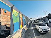  ??  ?? Residents of Rio’s favelas believe the Olympic wall is more disguise than decoration