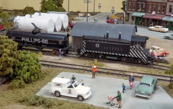  ??  ?? ❷ On a warm spring afternoon, father and son rail buffs watch as the local prepares to pull a tanker from Sanger Fuel & Oil. Other folks apparently have their eyes set on treats from the Good Humor man, whose favorite spot is the parking lot at the Sanger station.