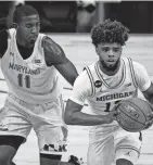  ?? MICHAEL CONROY/AP ?? Michigan guard Mike Smith (12) drives past Maryland guard Darryl Morsell (11) in the second half Friday in Indianapol­is.