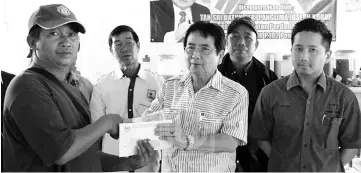  ??  ?? Minister in the Prime Minister's Department Tan Sri Joseph Kurup presenting BR1M to one of 156 recipients in Mukim Tatalaan, Nabawan on March 21. A national survey found 68.7 per cent of the respondent­s to be supportive of BR1M.