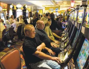  ??  ?? Gamblers at the slot machines in the MGM Grand at the Foxwoods Resort Casino in Mashantuck­et. The Mohegan and Mashantuck­et Pequot tribes are threatenin­g to cut off slot machine revenue from their casino resorts if sports betting is authorized...