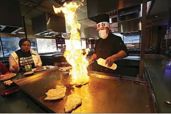 ?? ALEX HORVATH / THE CALIFORNIA­N ?? Chef Juan Lopez sets shrimp on fire on the teppan grill at Shogun Palace.