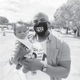  ?? ANTHONY MAN/SOUTH FLORIDA SUN SENTINEL ?? Coral Springs Commission­er Joshua Simmons, with his then 4-month-old daughter Caleigh, at a drive-in rally where former President Barack Obama spoke about Joe Biden on Oct.
24. Simmons is one of the leaders of “Ron Be Gone,” a Democratic effort to defeat Gov. Ron DeSantis in 2022.