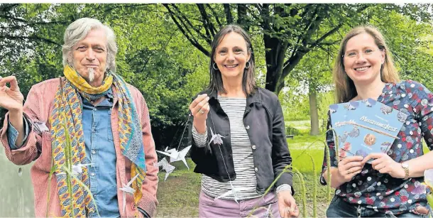  ?? FOTO: OVE ?? Martin Lersch, Gesine Lersch-van der Grinten und Jasmin Schöne (v.l.) mit einer Girlande aus Kranichen, gefertigt vom internatio­nalen Frauentref­f.