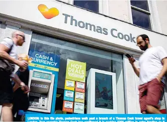  ??  ?? LONDON: In this file photo, pedestrian­s walk past a branch of a Thomas Cook travel agent’s shop in London. Tour operator Thomas Cook has confirmed it is seeking £200 million in extra funding as it attempts to prevent a collapse. —AFP