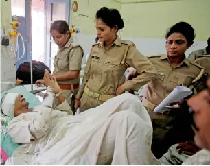  ?? Reuters ?? A victim, who was injured in the passenger train accident, talks to police personnel inside a government hospital in Muzaffarna­gar, Uttar Pradesh, on Sunday. —