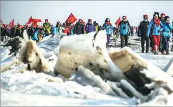  ?? PAN YULONG / XINHUA ?? Hikers walk on the ice in Panjin, Liaoning province, on Saturday. More than 4,100 people, including 20 from overseas, are participat­ing in a five-day challenge that includes hiking, camping and ice climbing.