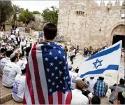  ?? LIOR MIZRAHI / GETTY IMAGES ?? A man wearing an American flag watches near Damascus Gate on Sunday as Israel marks Jerusalem Day, the 51st anniversar­y of the capture of the eastern part of the city during the Six Day War of 1967.