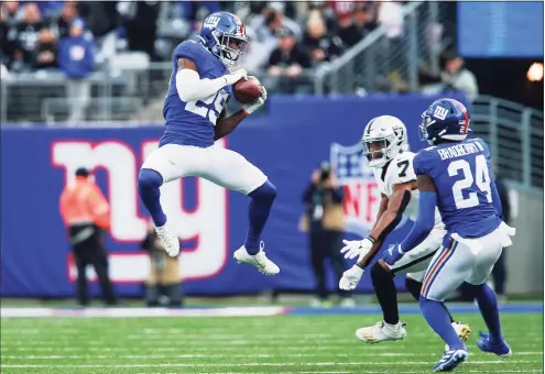  ?? John Munson / Associated Press ?? Giants free safety Xavier McKinney, left, intercepts a pass intended for the Raiders’ Zay Jones (7) during the second half Sunday.