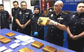  ??  ?? Johor Narcotics Criminal Investigat­ion Department chief ACP Lukas Aket (second right) and his officers show slabs of ganja seized in a raid last Thursday at a press conference at the Johor Police Contingent HQ. A man was arrested with 25 slabs of ganja...