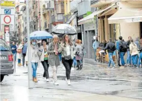  ?? Foto: Patxi Cascante ?? Varias personas pasean bajo la lluvia en Pamplona.