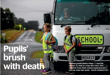  ?? DAVID UNWIN/STUFF ?? Kiwitea pupils Bailey Heap, 7, and Ebi Gibson, 9, wait to cross the road. Two children from their school experience­d a narrow miss last week.