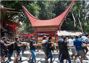  ??  ?? Last mile: Torajans carrying a coffin during the ‘Rambu Solo’ funeral ceremony at Londa in Tana Toraja regency. — AFP