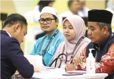  ?? — Bernama photo ?? Nor Idayu submitting her nomination papers flanked by her proposer and seconder.