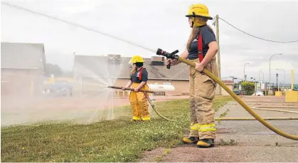  ?? ALISON JENKINS/LOCAL JOURNALISM INITIATIVE REPORTER ?? Junior firefighte­rs Anna Jesulaitis, left, and Macelynn Dwyer practise with the Borden-Carleton Fire Department.