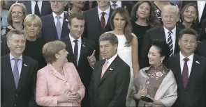  ?? MARKUS SCHREIBER THE ASSOCIATED PRESS ?? German Chancellor Angela Merkel, second from left, looks to France’s President Emmanuel Macron when posing for a photo prior to a concert on the first day of the G-20 summit in Hamburg, northern Germany, on Friday.