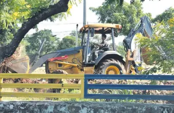  ??  ?? Tractor de la Municipali­dad realizando la compactaci­ón de escombros y basura en la ciclovía.