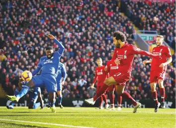  ?? AP ?? Liverpool’s Mohammad Salah scores his side’s first goal of the game against Cardiff City in Premier League action yesterday at Anfield. The goal was his fourth in three matches.