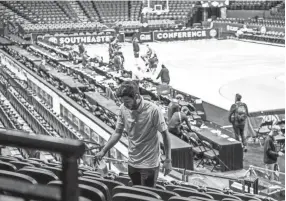  ?? BRIANNA PACIORKA/NEWS SENTINEL ?? Workers begin to disinfect seats inside Bridgeston­e Arena after the Southeaste­rn Conference decided to cancel the SEC Tournament over coronaviru­s concerns March 12.