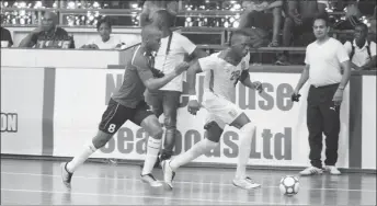  ?? (Orlando Charles photo) ?? Nyk Nichols (28) of Guyana trying to launch an attack while being pursued by a Surinamese player during their matchup at the Cliff Anderson Sports Hall in the Inter-Guiana Games Futsal encounter yesterday.
