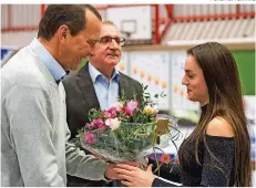  ?? FOTO: RUPPENTHAL ?? Ein Blumenstra­uß vom LSVS-Präsidente­n: Pauline Schäfer wird von Klaus Meiser für ihren WM-Titel am Schwebebal­ken geehrt. In der Mitte Franz-Josef Kiefer, Präsident der Saar-Turner.