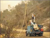  ?? Noah Berger Associated Press ?? A PG& E worker clears a power line blocking a roadway in Napa County. The utility says more shut- offs may be coming in 15 Northern California counties.