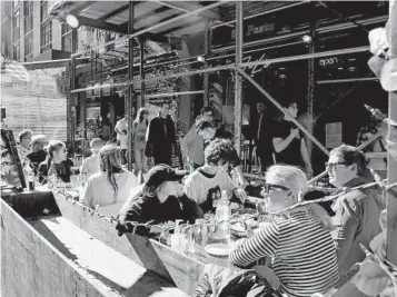  ?? AMIR HAMJA NYT ?? Diners eat at a sidewalk cafe in the Little Italy section of lower Manhattan. Investors and analysts are wondering when rising prices will start to keep more people away from restaurant­s.