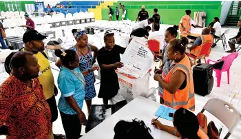  ?? — AFP photo ?? Electoral officers busy in ballot boxes verificati­on prior to start vote counting in Honiara, capital city of the Solomon Islands a day after the general elections.